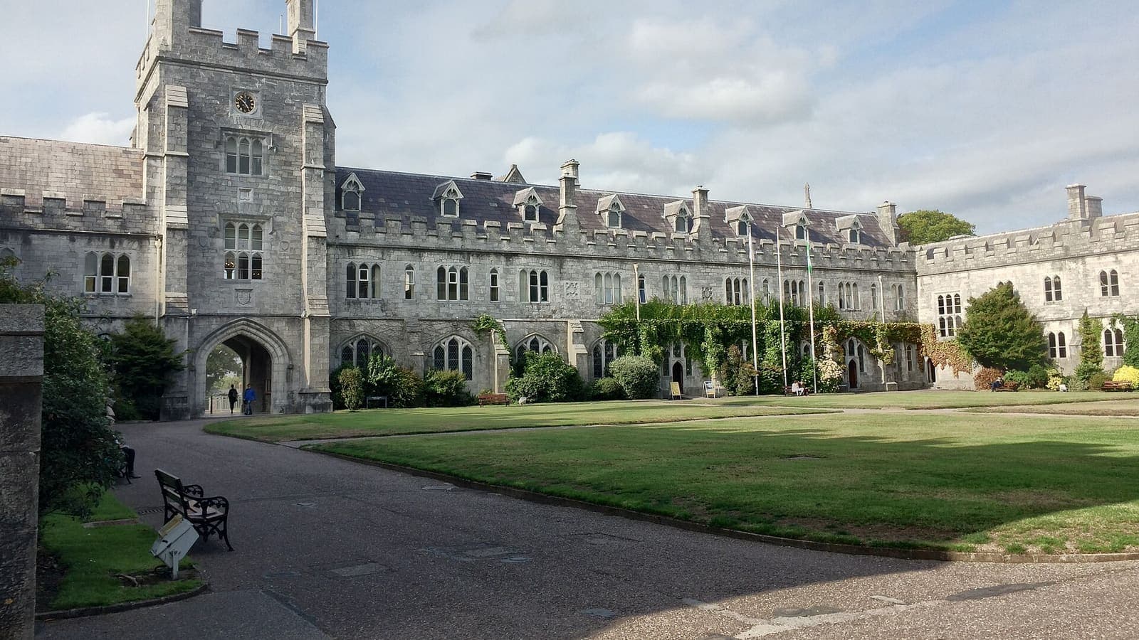 The Gothic limestone main quadrangle of University College Cork with its clock tower and lawn