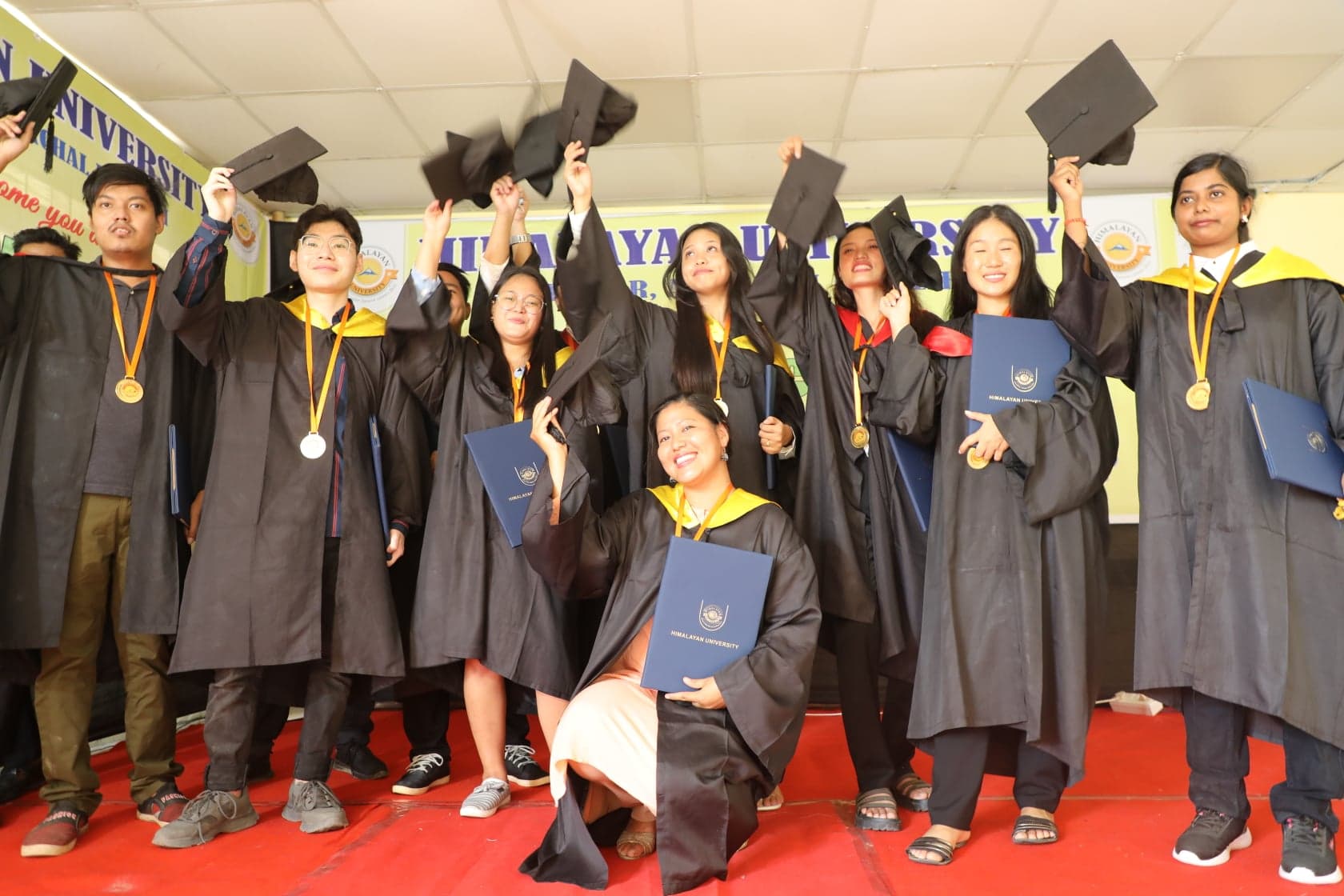 Graduating students in gowns throwing their caps at a university convocation in Nepal